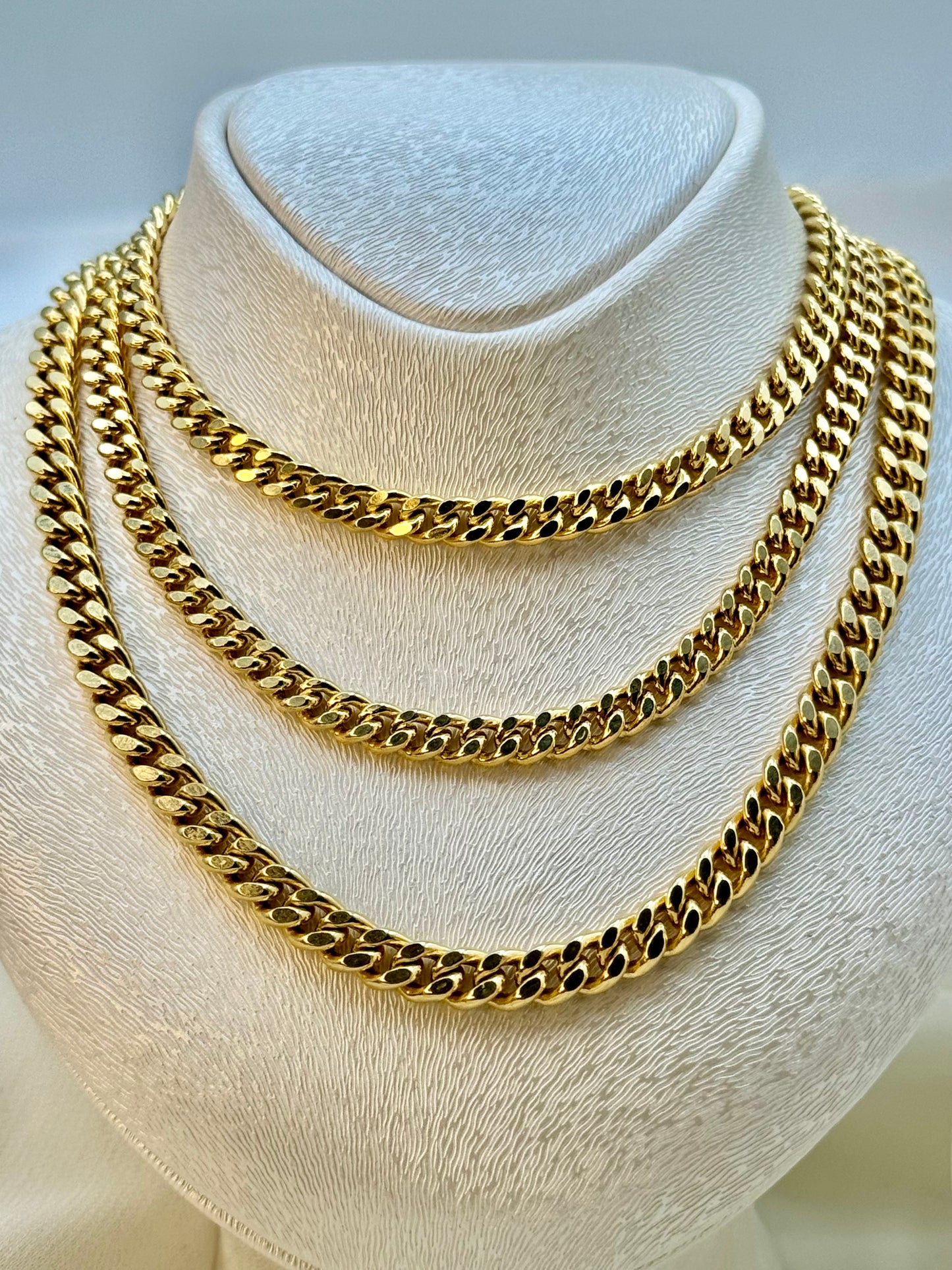 14k Gold curb chains stacked on display .