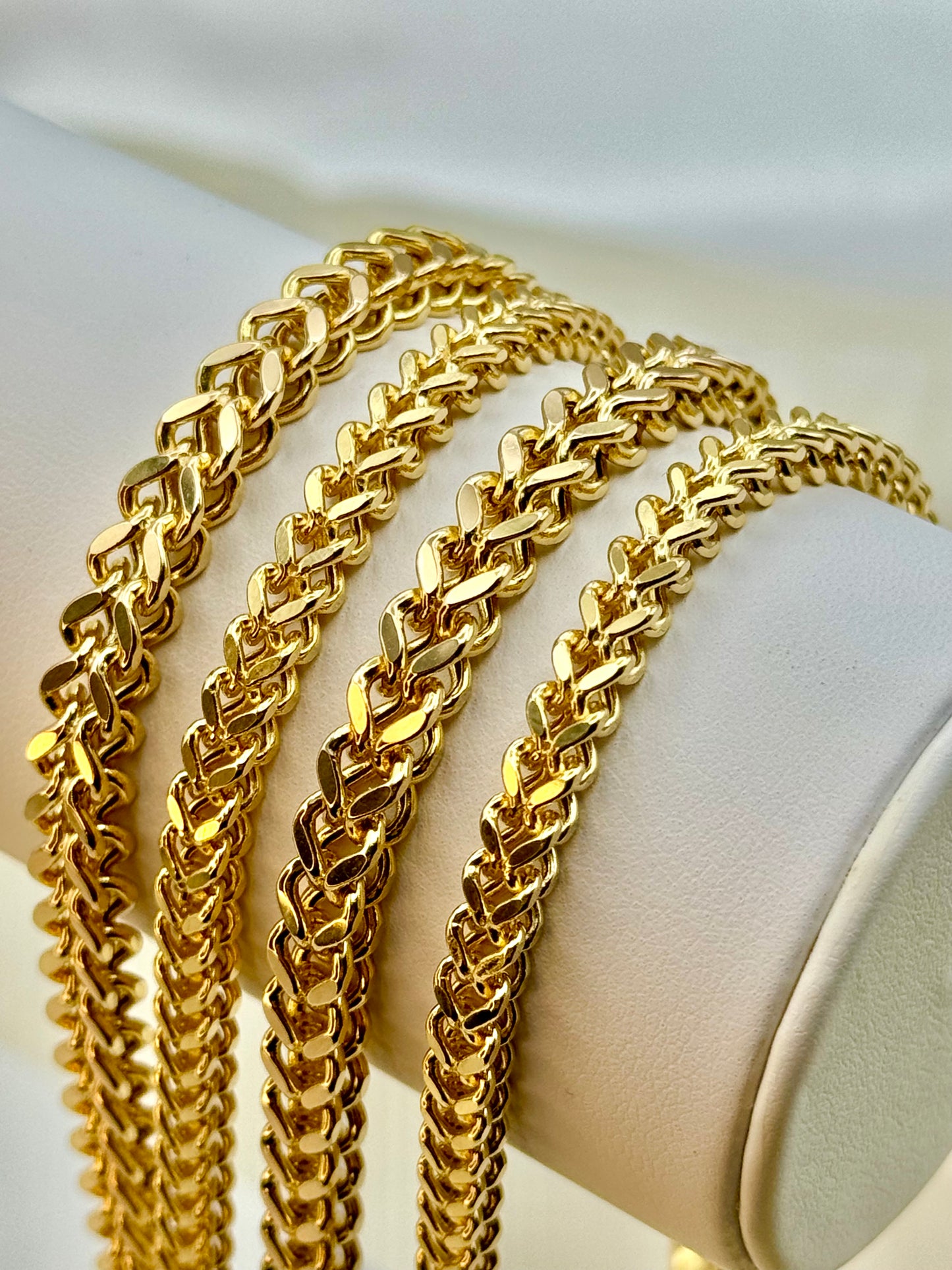 A 14K gold Franco chain necklace with a diamond cut design, displayed on a mannequin.