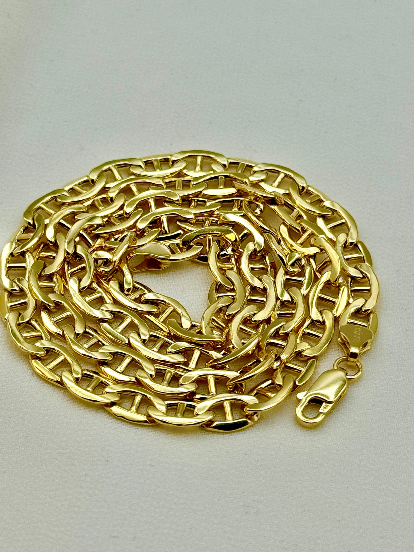 A coiled 14K gold anchor chain necklace with a lobster clasp on a white background.