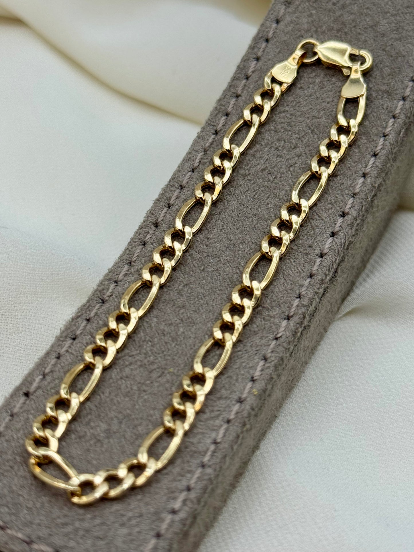 Gold chain necklace on a gray textured surface