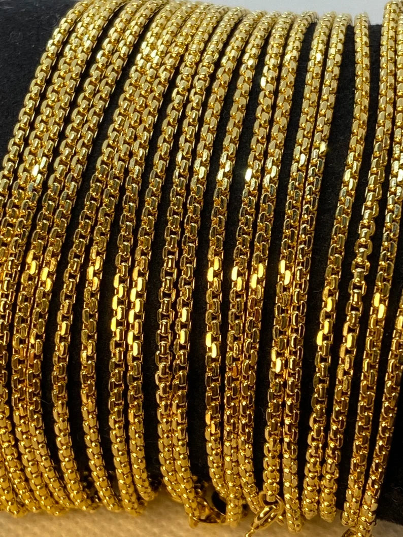 A collection of 18K solid gold box chain necklaces displayed side by side in varying lengths.
