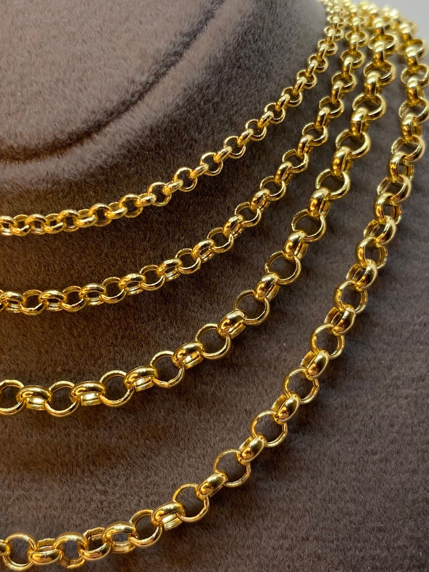A series of 14K gold rolo chain necklaces displayed on a mannequin.