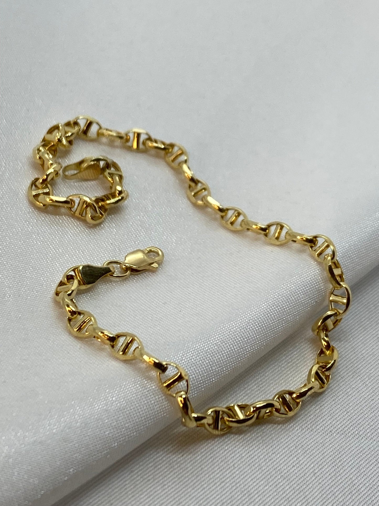 Gold anchor link bracelet .