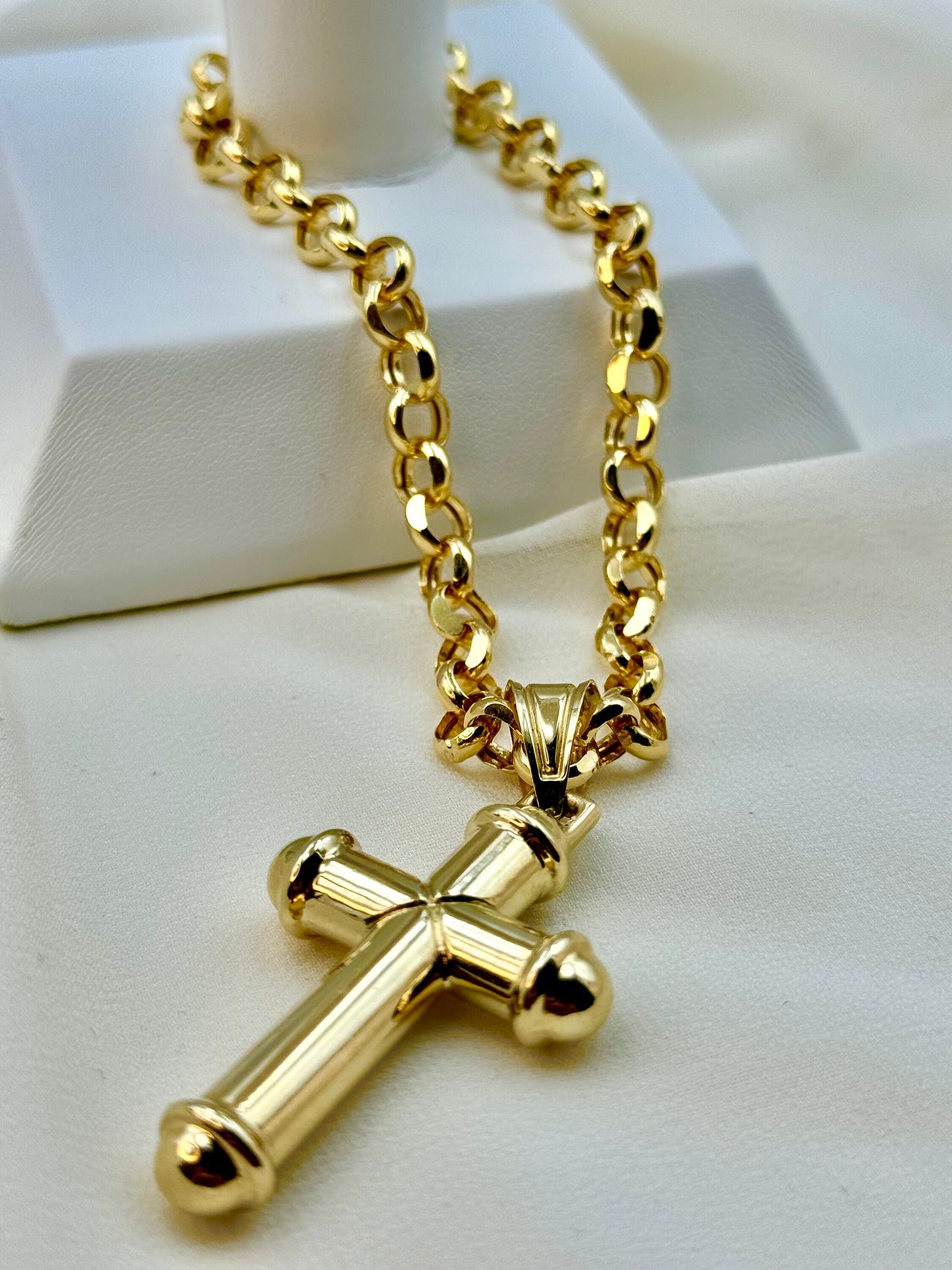 A 14K gold rolo chain necklace with a cross pendant, displayed on a white surface.