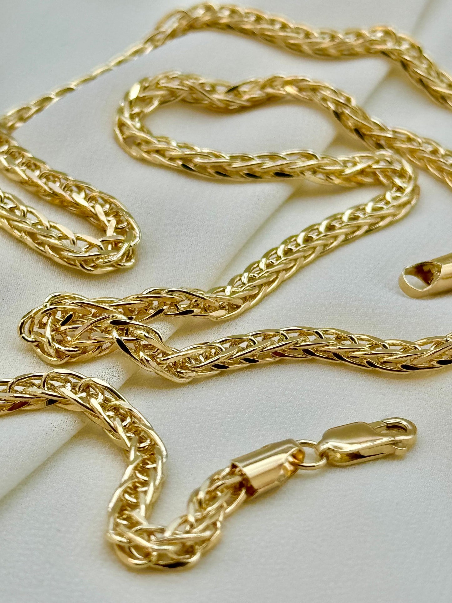 A 14k gold franco chain necklace with a foxtail diamond cut design, displayed on a white surface.