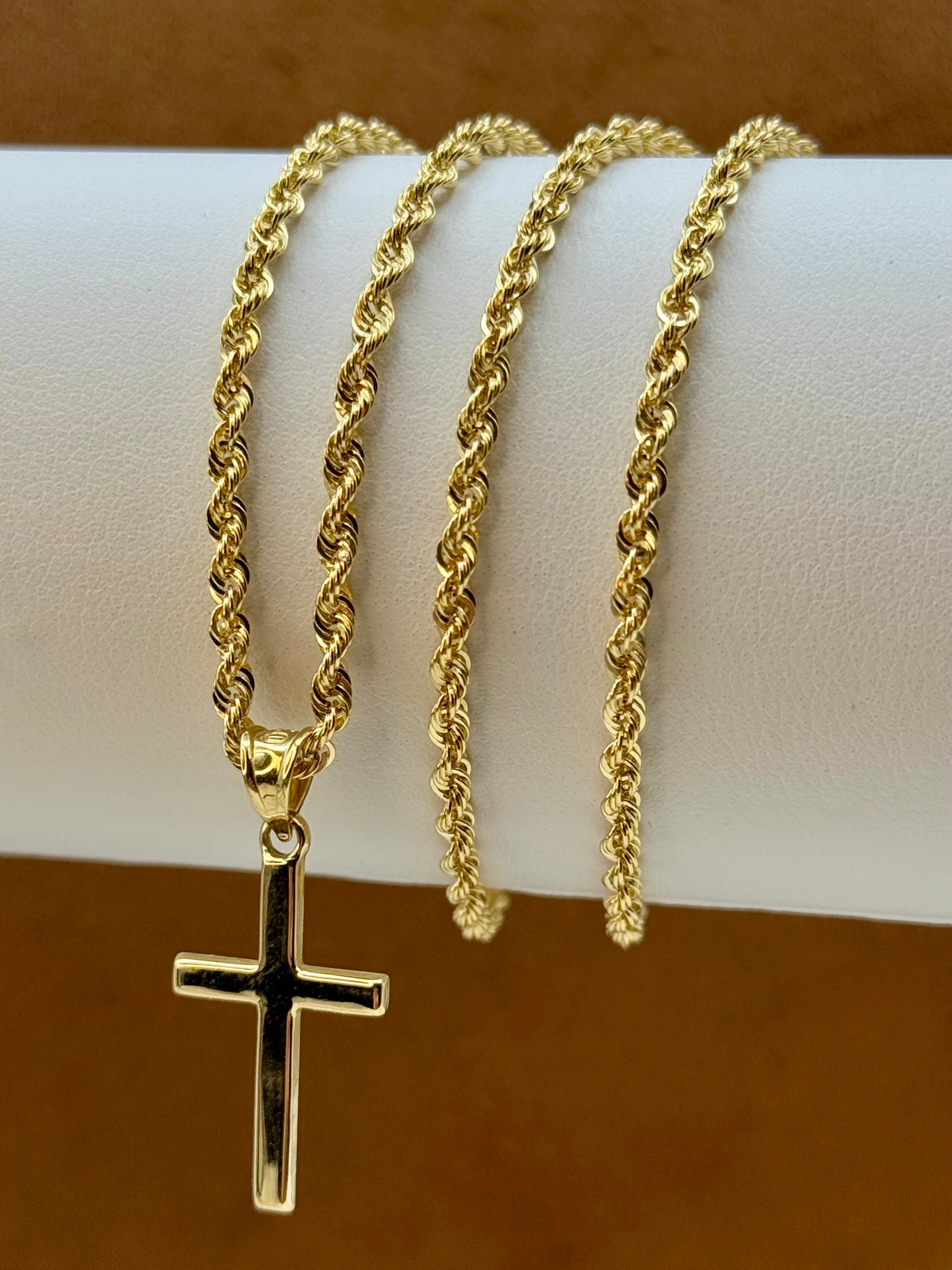 18k Gold necklace with a cross pendant on a white surface