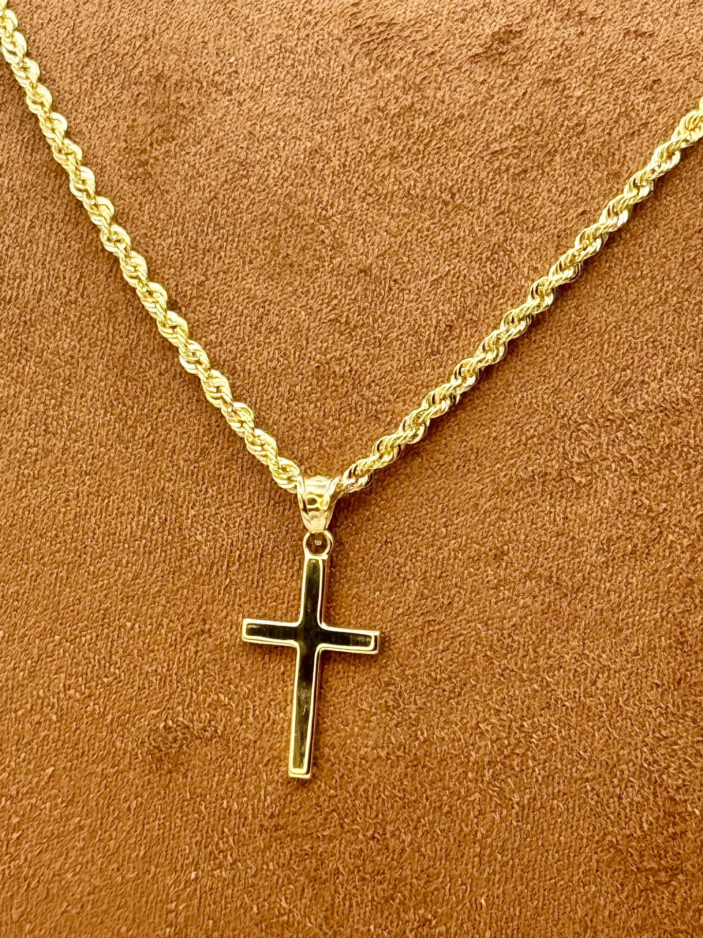 18k Gold necklace with a cross pendant on a brown background