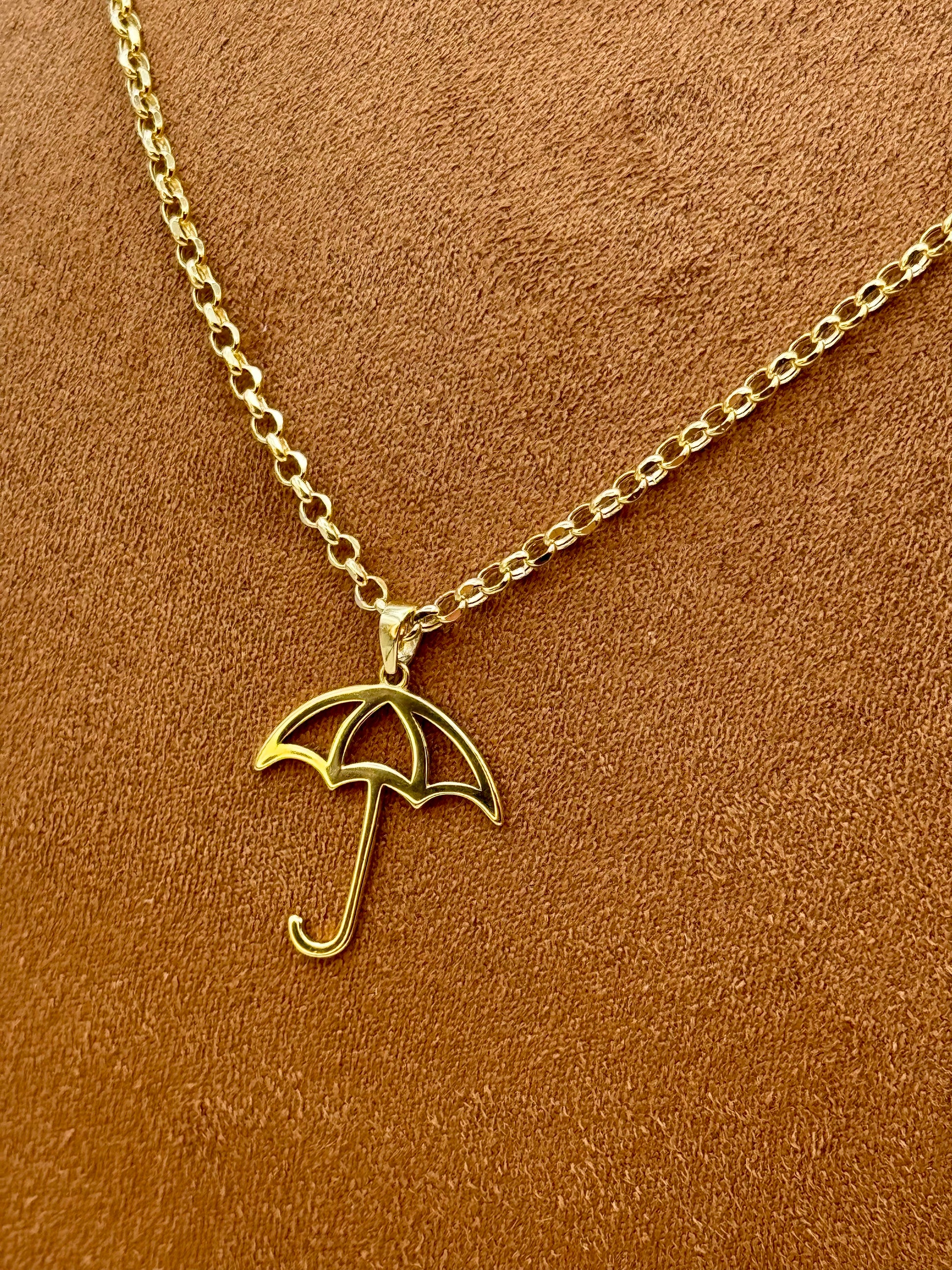 18k Gold umbrella necklace on a brown background