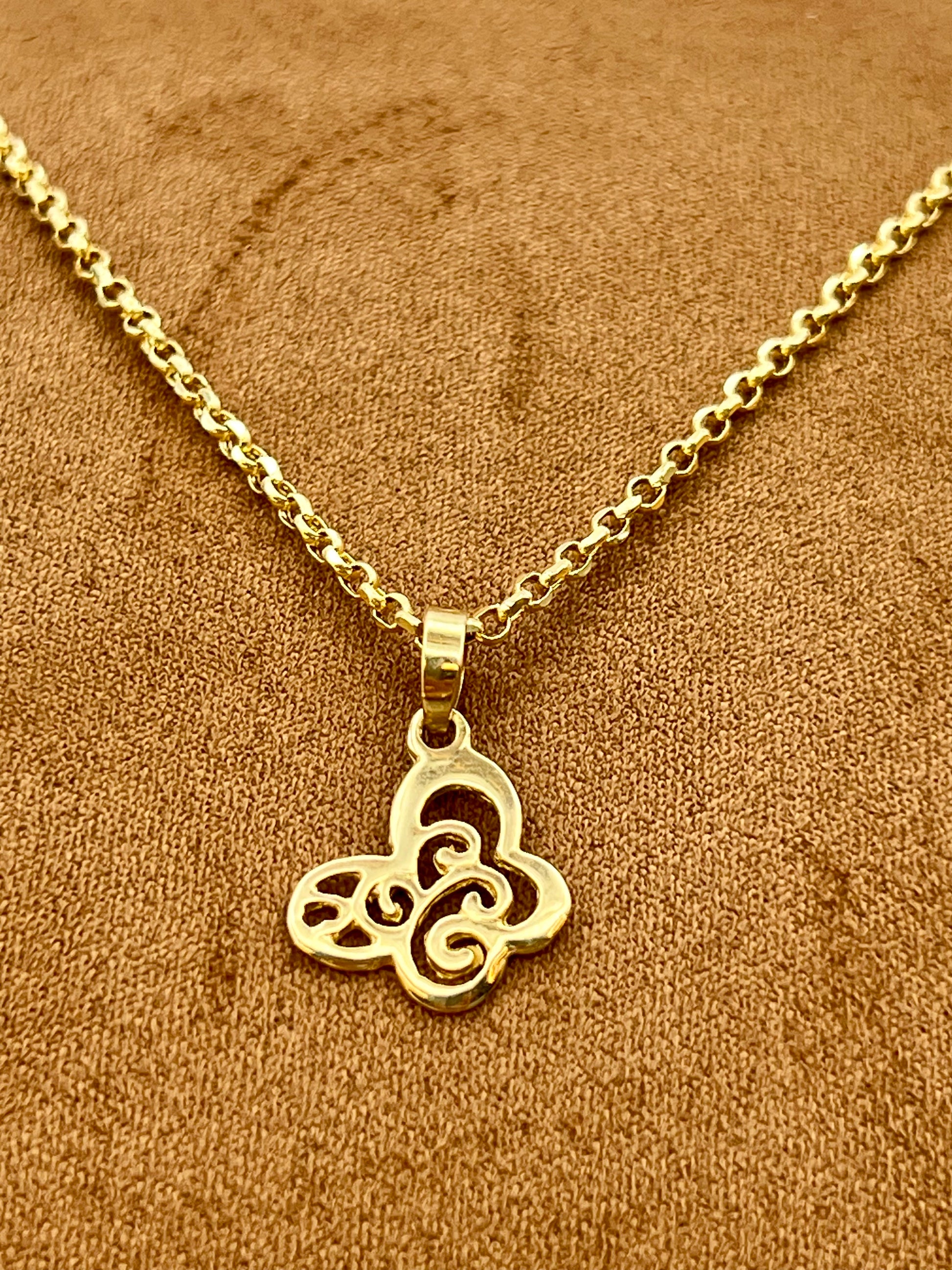 A gold-plated necklace with a Butterfly pendant, displayed on a textured brown fabric background.