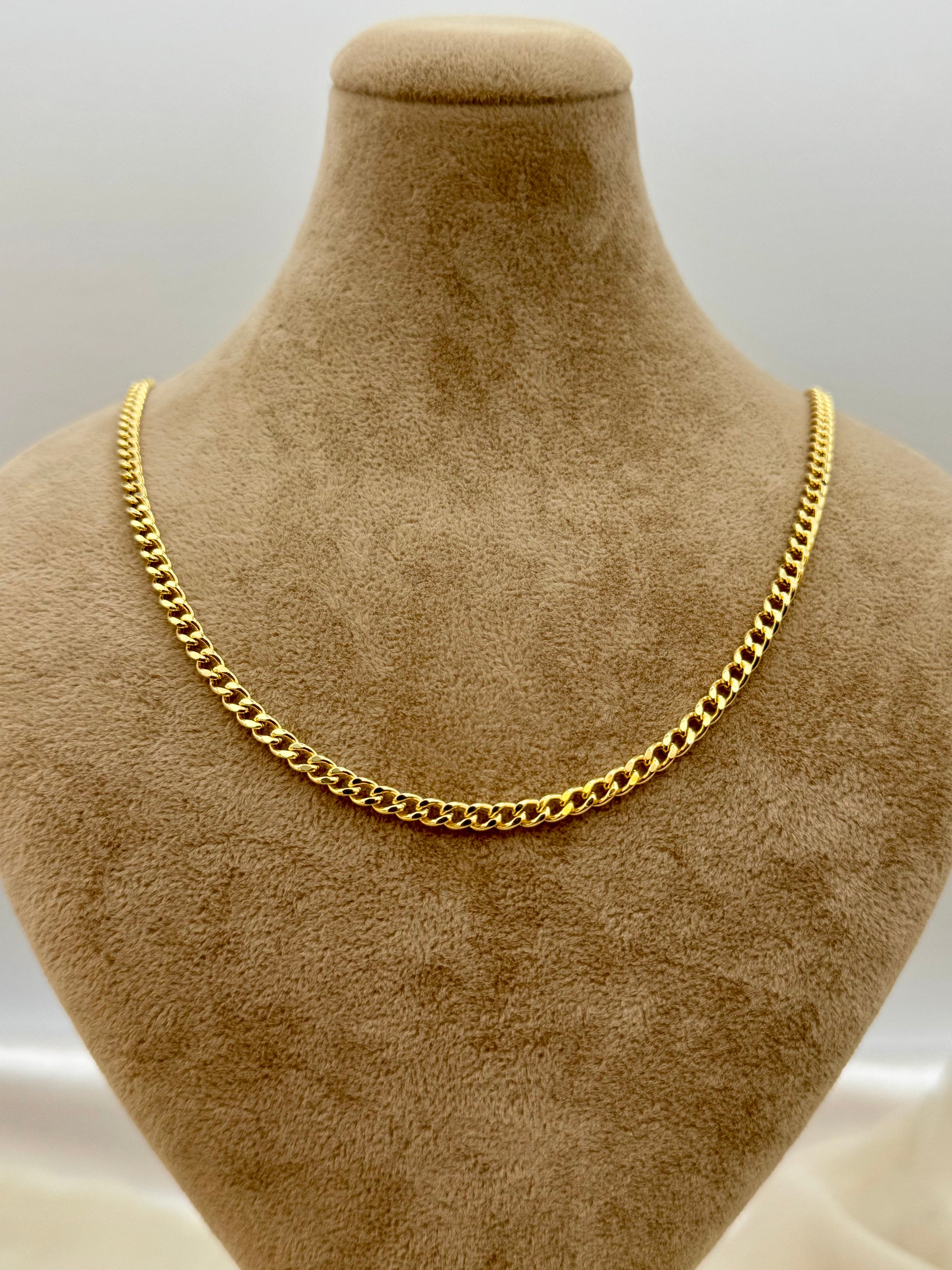18k Gold curb chain necklace on a brown mannequin bust against a white background