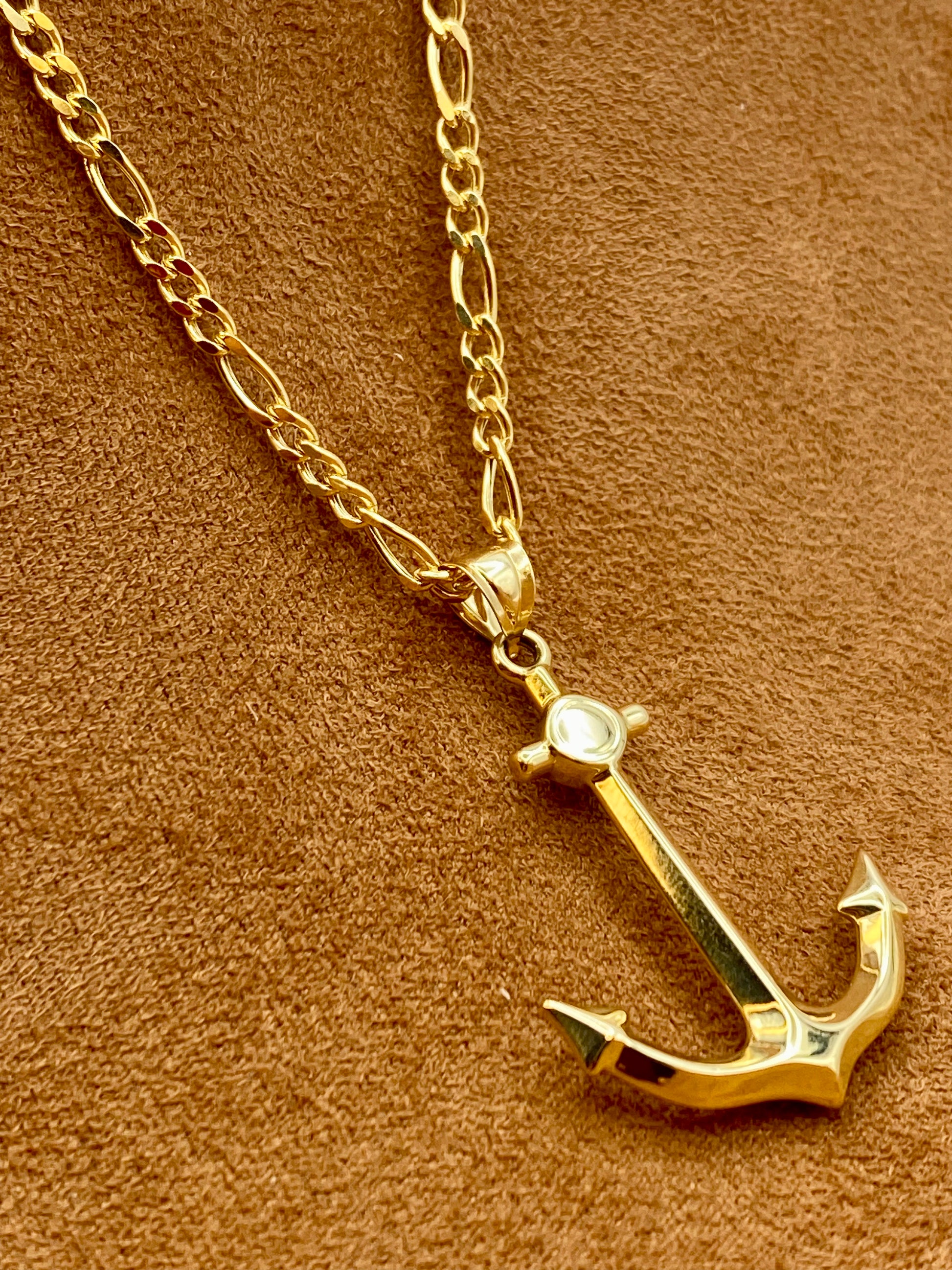 18k Gold anchor necklace on a brown textured background