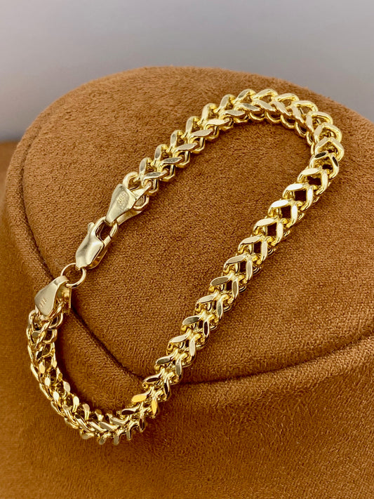 14k Franco Gold chain bracelet on a brown textured surface